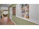 Hallway featuring built in shelving and display cases leading to a comfortably furnished living room at 5115 S Jules Verne Ct, Tampa, FL 33611