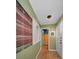 Hallway featuring a unique accent wall tapestry, complemented by natural light and a view of the bathroom at 5115 S Jules Verne Ct, Tampa, FL 33611