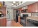 View of kitchen with brick floors and wood cabinets, showcasing modern appliances at 5115 S Jules Verne Ct, Tampa, FL 33611