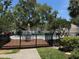 Community pool featuring a deck with table and chairs, black metal fence, and mature landscaping at 5115 S Jules Verne Ct, Tampa, FL 33611