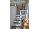 A charming staircase with a white railing leads to the entrance, surrounded by lush greenery and a patriotic windsock at 5115 S Jules Verne Ct, Tampa, FL 33611