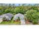 Aerial view showcasing the home's landscaped yard, neighborhood, and surrounding trees at 5143 New Brittany Ln, Zephyrhills, FL 33541
