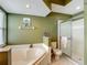 A bathroom features a garden tub and separate glass enclosed shower and modern fixtures at 5143 New Brittany Ln, Zephyrhills, FL 33541