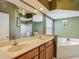 A double sink bathroom with a garden tub and separate glass enclosed shower at 5143 New Brittany Ln, Zephyrhills, FL 33541
