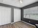 This is a bedroom with a grey accent wall, window, and a closet at 5143 New Brittany Ln, Zephyrhills, FL 33541