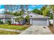 Charming single-story home featuring a well-manicured lawn, mature trees, and a two-car garage at 5143 New Brittany Ln, Zephyrhills, FL 33541