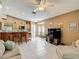 Living Room with ceiling fan, kitchen bar and breakfast seating area, tv and tile flooring at 5143 New Brittany Ln, Zephyrhills, FL 33541