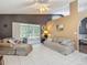 Spacious living room with screened porch access, neutral color palette, and tile flooring at 5143 New Brittany Ln, Zephyrhills, FL 33541