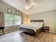 This is a main bedroom with a ceiling fan, large window, and a wooden headboard bed at 5143 New Brittany Ln, Zephyrhills, FL 33541