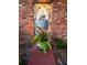 Charming exterior detail featuring a unique fountain and lush foliage in a colorful planter nestled against a brick wall at 530 59Th Ave, St Pete Beach, FL 33706