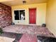 The front entrance is adorned with an eye-catching red brick wall, a bold red door, and charming brick pavers at 530 59Th Ave, St Pete Beach, FL 33706