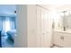 Bright bathroom featuring a white vanity, closet, and view of the bedroom with blue accents at 6805 S Gabrielle St, Tampa, FL 33611