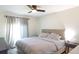 Bedroom with neutral tones, featuring a large bed, side table, and window with gray curtains at 6805 S Gabrielle St, Tampa, FL 33611