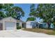 Well-manicured front yard leads to a single-story home, with a charming exterior and attached garage at 6805 S Gabrielle St, Tampa, FL 33611