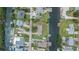 Aerial view displays surrounding homes and neighborhood relative to the canal and street at 814 Seabreeze Dr, Ruskin, FL 33570