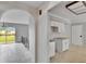 Open floor plan with archway, kitchen with granite countertops, and access to a screened patio at 814 Seabreeze Dr, Ruskin, FL 33570