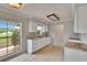 Bright kitchen with white cabinetry, granite countertops, tile flooring, and large window views at 814 Seabreeze Dr, Ruskin, FL 33570