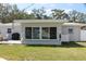 Backyard showcases a well-manicured lawn, patio area, and large windows offering abundant natural light at 8347 41St N Ave, St Petersburg, FL 33709