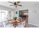 Sunlit dining area featuring a round table with seating, an elegant ceiling fan, and an open layout leading to the living spaces at 8347 41St N Ave, St Petersburg, FL 33709