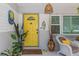 Charming yellow front door with sidelight, fun decor, and a covered porch for welcoming guests at 8347 41St N Ave, St Petersburg, FL 33709
