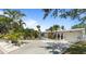 Charming single-story home featuring a well-manicured lawn and tropical landscaping with a light grey painted exterior at 8347 41St N Ave, St Petersburg, FL 33709