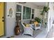 Inviting front porch featuring stylish white wicker seating, neutral rug, and tropical accents at 8347 41St N Ave, St Petersburg, FL 33709