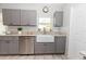 Updated kitchen with gray cabinets, white farmhouse sink, and stainless steel appliances at 8347 41St N Ave, St Petersburg, FL 33709