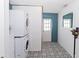 Practical laundry room with stacked washer and dryer, tiled flooring, and ample space for storage at 8347 41St N Ave, St Petersburg, FL 33709
