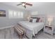 Comfortable main bedroom showcasing a queen-size bed, neutral tones, shuttered window, and wood-look flooring at 8347 41St N Ave, St Petersburg, FL 33709