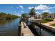 Modern boat and dock along the canal with well-manicured landscaping and blue skies at 9301 Sun Isle Ne Dr, St Petersburg, FL 33702