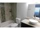 A stylish bathroom with a modern vanity, a tub, and decorative tile at 9481 Highland Oak Dr # 1003, Tampa, FL 33647