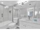 Bright bathroom with a combined shower and bathtub, white tiling, and a large mirror at 9495 Blind Pass Rd # 907, St Pete Beach, FL 33706