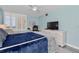 Bedroom showcasing a light blue color scheme, ceiling fan, and a large dresser with a TV at 9495 Blind Pass Rd # 907, St Pete Beach, FL 33706