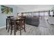 Open floorplan living room and dining area with hardwood floors and large windows with a view at 9495 Blind Pass Rd # 907, St Pete Beach, FL 33706