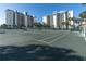 Well-maintained tennis court with lush surroundings and high-rise building backdrop at 9495 Blind Pass Rd # 907, St Pete Beach, FL 33706