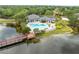 Aerial view showcases a community pool with a unique shape, a lake and clubhouse, with mature landscaping at 10028 Strafford Oak Ct # 712, Tampa, FL 33624