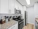 This kitchen features white cabinets, granite counters and stainless steel appliances at 10028 Strafford Oak Ct # 712, Tampa, FL 33624