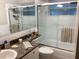 Bright bathroom featuring a shower-tub combination with glass doors and modern fixtures at 101 Madonna Blvd, St Petersburg, FL 33715