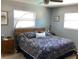 Calm bedroom with a patterned comforter, neutral walls, and natural light from two windows at 101 Madonna Blvd, St Petersburg, FL 33715