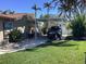 Carport area with motorcycle and truck parked, surrounded by lush tropical landscaping and blue skies at 101 Madonna Blvd, St Petersburg, FL 33715