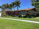 Charming single-story home with beautiful landscaping, mature palm trees, and well-maintained lawn on a sunny day at 101 Madonna Blvd, St Petersburg, FL 33715