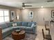 Comfortable living room with large blue sectional sofa, ceiling fan, and bright natural light at 101 Madonna Blvd, St Petersburg, FL 33715