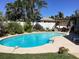 Inviting kidney-shaped pool surrounded by a white fence and lush tropical foliage at 101 Madonna Blvd, St Petersburg, FL 33715
