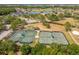Aerial view showcases bocce ball courts, tennis courts, and the surrounding residential area at 1046 Almondwood Dr, Trinity, FL 34655