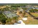 Aerial view featuring tennis courts, a lake, and sand traps within the community at 1046 Almondwood Dr, Trinity, FL 34655