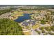 Aerial view of the community, showcasing the large clubhouse, surrounding homes, and picturesque lake at 1046 Almondwood Dr, Trinity, FL 34655