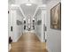 Hallway with white trim, wood-look floors, and a decorative gold table with an elegant floral arrangement at the end at 1046 Almondwood Dr, Trinity, FL 34655