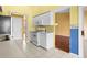 Well-lit kitchen featuring white appliances, tile floors, and a doorway to the living room at 1046 Almondwood Dr, Trinity, FL 34655
