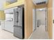 Well-lit kitchen featuring stainless steel appliances, white cabinets, and a doorway to the laundry room at 1046 Almondwood Dr, Trinity, FL 34655