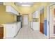 Well-lit kitchen featuring white appliances, tile floors, and a doorway to the living room at 1046 Almondwood Dr, Trinity, FL 34655